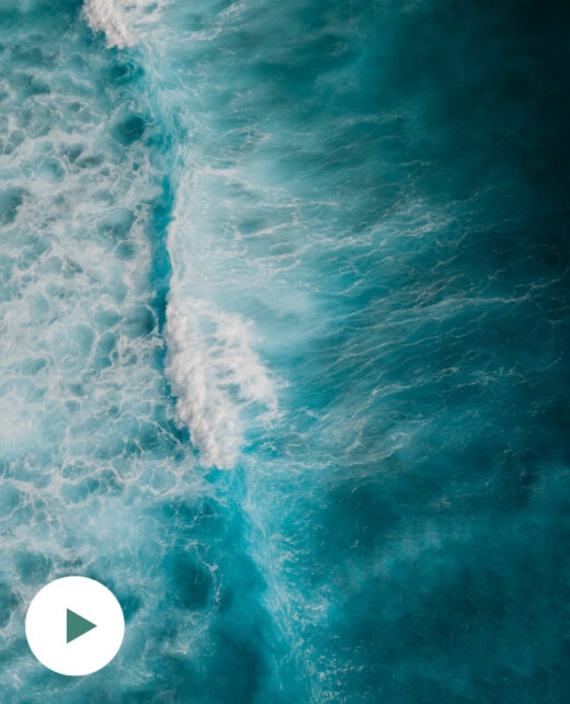 Symbolbild: Blick von oben auf Wellen und schäumendes, tiefes Wasser.